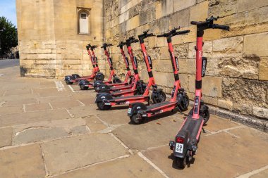 OXFORD, İngiltere - 11 Haziran 2022: Bir yaz günü Oxford 'da bir sokakta VOI şirketi tarafından kiralanan elektrikli scooterlar