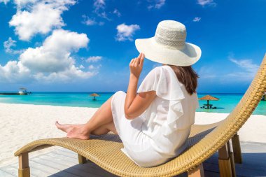 Güneşli bir yaz gününde lüks bir tropik plajda güneşlenen güzel bir kadın.
