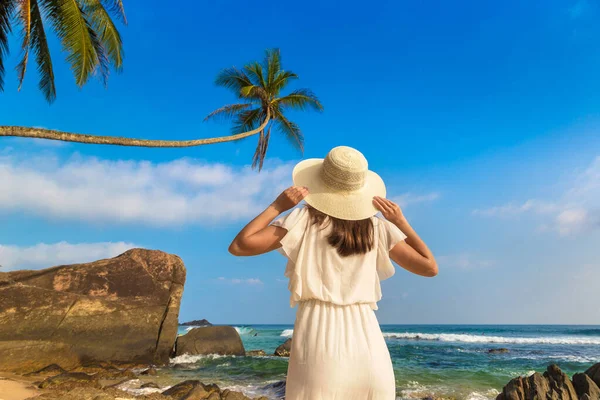 海の近くの熱帯のビーチに滞在帽子と白いドレスを身に着けている若い美しい女性の肖像画 — ストック写真
