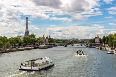 Fransa 'nın güneşli bir yaz gününde Paris' teki Seine Nehri 'nde Eyfel kulesi ve nehir teknesi.