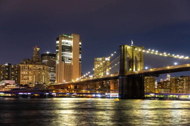 Brooklyn Köprüsü ve Manhattan şehir merkezinin panoramik gece görüntüsü New York City, ABD 'de gün batımından sonra