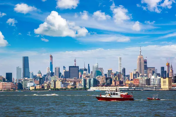 Jersey City Fire Department boat on the Hudson River against Manhattan cityscape background, USA