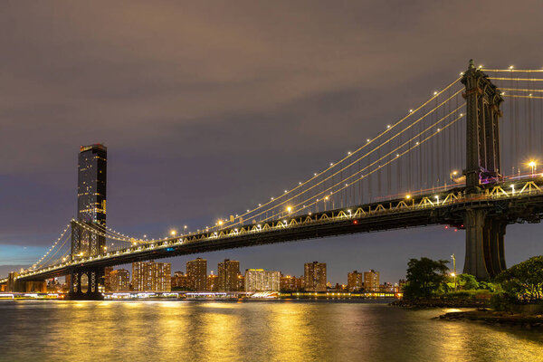Manhattan Bridge and panoramic night view of downtown Manhattan after sunset in New York City, USA