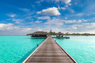 Water Villas (Bungalows) and wooden bridge at Tropical beach in the Maldives at summer day clipart