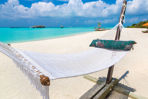 Romantic cozy hammock at tropical paradise ocean beach in a sunny summer day