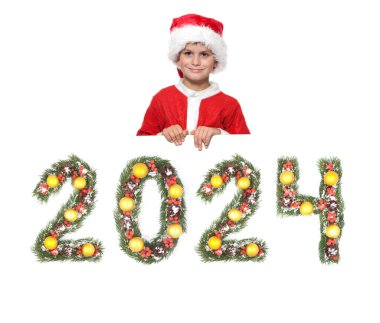 Çocuk Noel Baba 'nın elinde bir noel posteri var ve 2024 numara beyaz arka planda izole edilmiş noel ağacı dalları tarafından yapılmış.