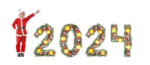 白い背景に隔離されたクリスマスツリーの枝で作られたサンタクロースと2024の番号を着た少年 — ストック写真