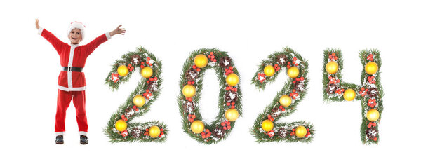 Мальчик одет как Санта-Клаус и 2024 номер сделан рождественские ветви елки изолированы на белом фоне