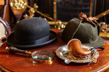 LONDON, BİRLİK KINGDOM - 26 Haziran 2022: İkonik büyüteç, cam, şapka ve sigara piposu Londra, İngiltere 'de Baker Caddesi' ndeki Sherlock Holmes Müzesi 'nde