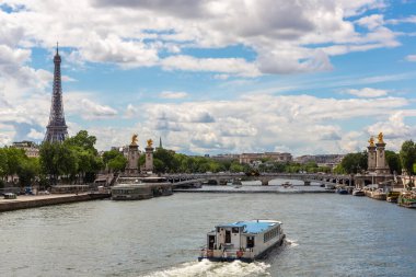 Fransa 'nın güneşli bir yaz gününde Paris' teki Seine Nehri 'nde Eyfel kulesi ve nehir teknesi.