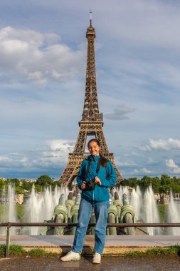 Eiffel Kulesi 'nde kadın gezgin ve Paris, Fransa' da gün batımında Trocadero çeşmeleri.