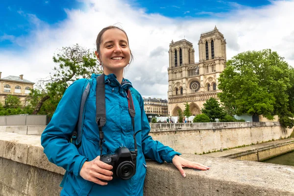 Woman traveler at Notre Dame de Paris is the one of the most famous symbols of Paris in a summer day, France