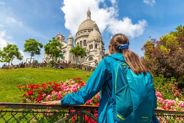 Woman traveler at Basilica of the Sacred Heart at Montmartre hill in Paris (Basilica of Sacre Coeur) in a summer day, France