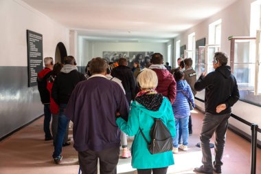 OSWIECIM, POLAND - 7 Eylül 2022: Güneşli bir günde Auschwitz toplama kampındaki fotoğraf sergisinde bir grup turist, Oswiecim, Polonya