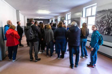 OSWIECIM, POLAND - 7 Eylül 2022: Güneşli bir günde Auschwitz toplama kampındaki fotoğraf sergisinde bir grup turist, Oswiecim, Polonya