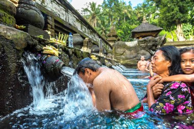 BALI, INDONEZYA - 28 Şubat 2020: Bali halkı Endonezya 'nın Bali kentindeki Pura Tirta Empul Tapınağı' ndaki kutsal havuzda dua ediyor