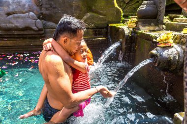 BALI, INDONEZYA - 28 Şubat 2020: Bali halkı Endonezya 'nın Bali kentindeki Pura Tirta Empul Tapınağı' ndaki kutsal havuzda dua ediyor