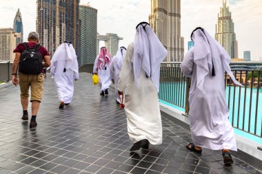 DUBAI, BAE - 5 Nisan 2020: Dubai şehir merkezinde, Birleşik Arap Emirlikleri 'nde geleneksel beyaz elbiseler giyen Arap erkekler