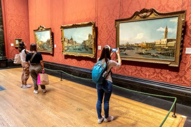 LONDON, İngiltere - 8 Eylül 2023: Ziyaretçi, Londra 'daki Trafalgar Meydanı' ndaki Ulusal Galeri 'de asılı duran yağlı boya tablonun fotoğrafını çekiyor