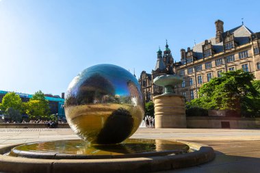 SHEFFIELD, İngiltere - 16 Haziran 2022: Heykel paslanmaz çelik küreler ve Sheffield Belediye Binası güneşli bir yaz günü Sheffield, Güney Yorkshire, İngiltere