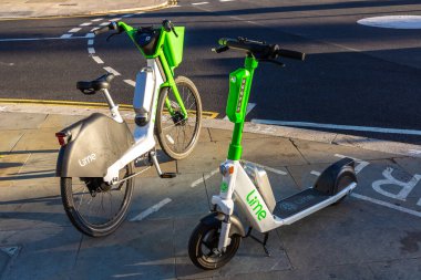 LONDON, İngiltere - 17 Haziran 2022: Güneşli bir yaz gününde Londra 'da bir sokakta modern Lime elektrikli bisiklet ve elektrikli scooter