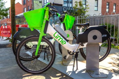 DERBY, İngiltere - 4 Eylül 2023: İngiltere 'nin Derby şehrinde güneşli bir günde Lime tarafından bir liman istasyonunda bisiklet kiralanması