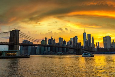 Brooklyn Köprüsü 'nün günbatımı ve New York City, ABD' deki Manhattan şehir merkezinin panoramik manzarası.