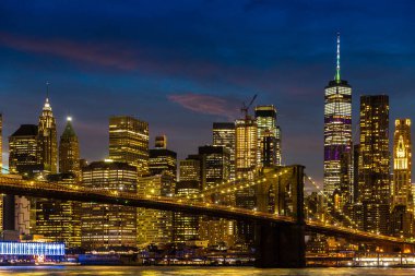 Brooklyn Köprüsü ve Manhattan şehir merkezinin panoramik gece görüntüsü New York City, ABD 'de gün batımından sonra