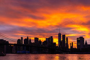 Brooklyn Köprüsü 'nün günbatımı ve New York City, ABD' deki Manhattan şehir merkezinin panoramik manzarası.