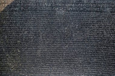 LONDON, İngiltere - 27 Ocak 2025: Britanya Müzesi 'nde sergilenen ikonik Rosetta Taşı' nın detaylı görünümü, antik Mısır hiyerogliflerinin deşifre edilmesine yardımcı olan üç metinde yazıtlar sergileniyor