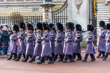 Londra, Buckingham Sarayı 'ndaki muhafız değişiminde, izleyiciler tarafından izlenen merasim üniformalı bir İngiliz muhafız alayı tüfeklerle yürür.