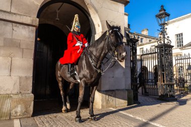 LONDON, İngiltere - 30 HAZİRAN 2025: Kırmızı tören üniforması ve altın kasklı bir Süvari askeri, Londra 'daki Household Süvari Müzesi' nde, İngiliz Ordusu tören geleneğinin bir parçası olan at sırtında oturuyor