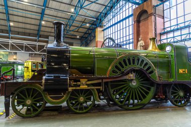 YORK, İngiltere - 6 Şubat 2025: Iconic GNR Stirling Single 4-2-2 ihale lokomotifi York 'taki Ulusal Demiryolu Müzesi' nde sergilenmektedir. Bu motor 19. yüzyıl İngiliz demiryolu yeniliğini ve tasarımını yansıtır.