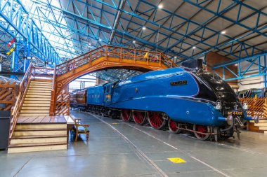 YORK, İngiltere - 6 Şubat 2025: Iconic Mallard buharlı lokomotifi (Hayır. 4468), dünya hız rekoru sahibi, canlı mavi dizayn ve çarpıcı kırmızı tekerleklerle York 'taki Demiryolu Müzesi' nde sergilenmektedir.