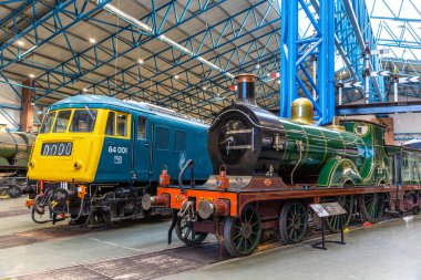 YORK, İngiltere - 6 Şubat 2025: D sınıfı buharlı lokomotifin yan yana görüntüsü No. 737 (1901) ve British Rail Class 84 elektrikli lokomotif No. York Demiryolu Müzesi 'nde 84 001.