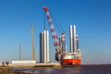 HULL, İngiltere - 18 Mart 2025: Rüzgar Tepesi, modern bir açık deniz rüzgar yükleme gemisi, Hull, İngiltere 'de demirli Siemens Gamesa rüzgar türbini bileşenleri off-shore rüzgar çiftliklerinde konuşlandırmak için yükleniyor
