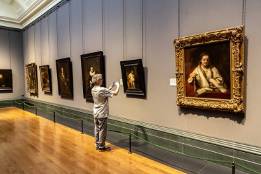 LONDON, İngiltere - 8 Eylül 2023: Ziyaretçi, Londra 'daki Trafalgar Meydanı' ndaki Ulusal Galeri 'de asılı duran yağlı boya tablonun fotoğrafını çekiyor