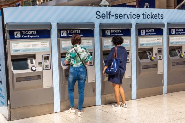LONDON, BİRLİK KINGDOM - 26 Haziran 2022: Londra, İngiltere 'de bir yaz günü Waterloo tren istasyonunda self servis biletleri makinesi