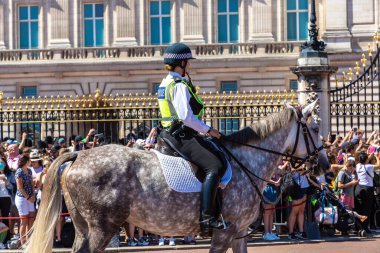 LONDON, İngiltere - 17 Haziran 2022: Londra 'da güneşli bir yaz günü Buckingham Sarayı' nın önünde düzenlenen koruma seremonisinin değişmesi için Metropolitan atlı polis devriyesi