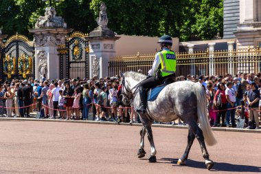 LONDON, İngiltere - 17 Haziran 2022: Londra 'da güneşli bir yaz günü Buckingham Sarayı' nın önünde düzenlenen koruma seremonisinin değişmesi için Metropolitan atlı polis devriyesi
