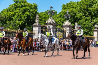 LONDON, İngiltere - 17 Haziran 2022: Londra 'da güneşli bir yaz günü Buckingham Sarayı' nın önünde düzenlenen koruma seremonisinin değişmesi için Metropolitan atlı polis devriyesi
