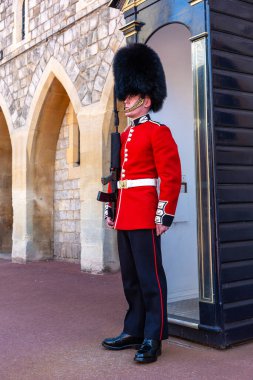 WINDSOR, İngiltere - 19 Haziran 2022 Windsor, İngiltere 'de güneşli bir yaz gününde Kraliyet Muhafızları Windsor Kalesi' nde görevdedir.
