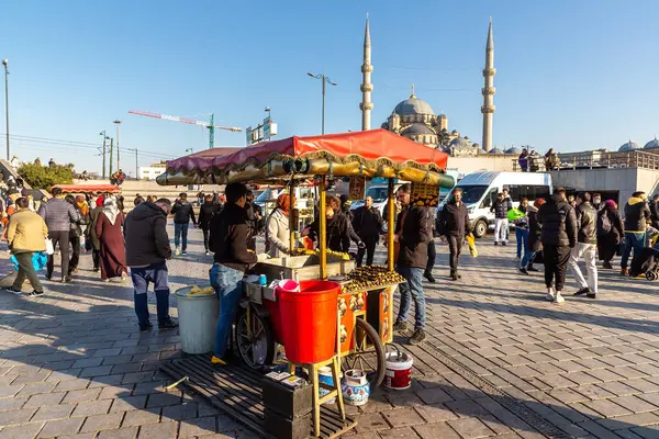 İSTANBUL, TURKEY - 10 Nisan 2022: Türkiye 'nin İstanbul kentinde, güneşli bir günde geleneksel Türk ızgara mısırı satan sokak Türk satıcısı