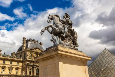 PARIS, FRANCE - 16 Haziran 2022 Louis Heykeli ve Louvre, Fransa 'nın başkenti Paris' te bir yaz günü dünyanın en büyük müzelerinden biridir.