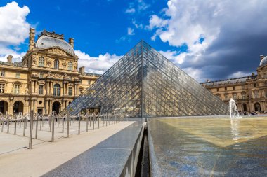 PARIS, FRANCE - Haziran 01, 2022: Louvre and Pyramid - Fransa 'nın bir yaz gününde Paris' teki dünyanın en büyük müzelerinden biridir.
