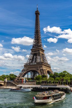 Fransa 'nın güneşli bir yaz gününde Paris' teki Seine Nehri 'nde Eyfel kulesi ve nehir teknesi.