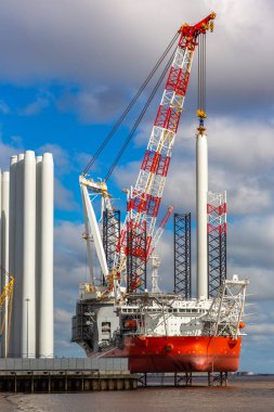 HULL, UK - 20 Nisan 2025: Rüzgar Tepesi, modern bir açık deniz rüzgar yükleme gemisi, Siemens Gamesa rüzgar türbini bileşenlerini off-shore rüzgar çiftliklerine yerleştirmek üzere İngiltere 'nin Hull kentinde demirledi.