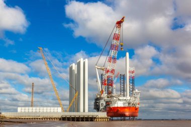 HULL, UK - 20 Nisan 2025: Rüzgar Tepesi, modern bir açık deniz rüzgar yükleme gemisi, Siemens Gamesa rüzgar türbini bileşenlerini off-shore rüzgar çiftliklerine yerleştirmek üzere İngiltere 'nin Hull kentinde demirledi.