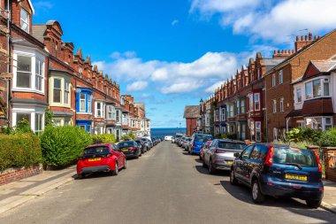 SALTBURN-By-The-SEA, İngiltere - 28 Haziran 2025: Park edilmiş arabaları ve okyanus manzaralı Viktorya tarzı Diamond Caddesi, Saltburn-by-Sea, İngiltere, İngiltere