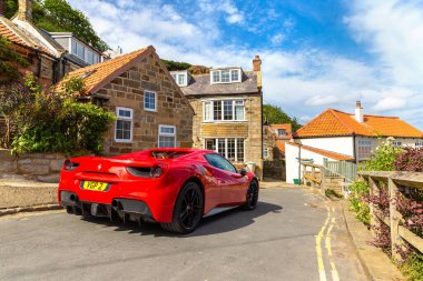 RUNSWICK BAY, İngiltere - 28 Haziran 2025: Runswick Bay, İngiltere, İngiltere 'de dar bir kıyı yolunda kırmızı Ferrari 488 Spider